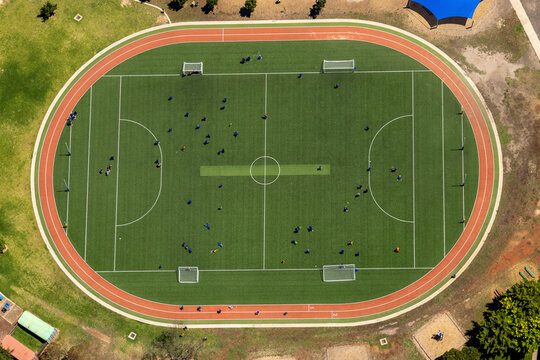 Aerial view of a vibrant soccer field with players in action and a running track, Melton West, Victoria, Australia.