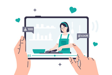 A person watches a video recipe on a tablet, where a food blogger girl is cooking. Hands are holding a tablet on which a video on a culinary topic is playing. The display shows the number of views