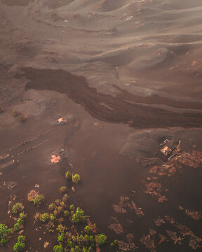 Aerial view of volcanic eruption aftermath with buried houses and lava flow amidst scorched earth, El Paso, Santa Cruz de Tenerife, Spain.