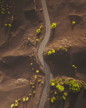 Aerial view of volcanic landscape with winding road and greenery, El Paso, Santa Cruz de Tenerife, Spain.