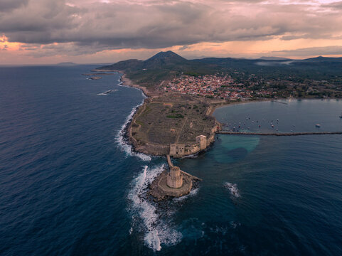 Aerial view of ancient fortress ruins by the tranquil sea at sunrise, Methoni, Greece.