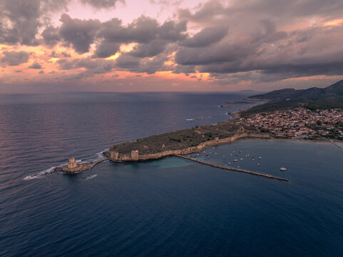 Aerial view of ancient castle ruins and a medieval fortress by the serene coast and beautiful sea at sunrise, Methoni, Greece.