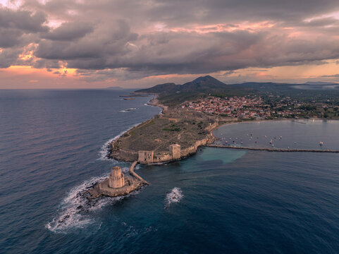 Aerial view of ancient medieval fortress and tower by the beautiful coast and sea at sunrise, Methoni, Greece.