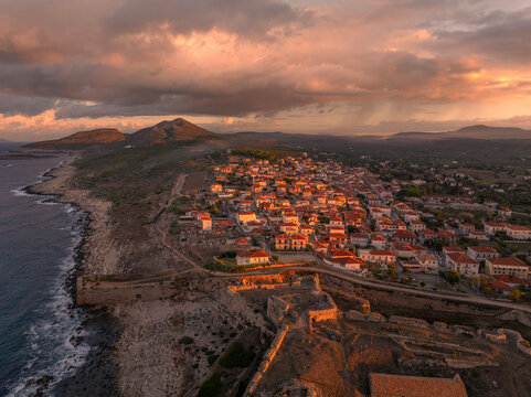 Aerial view of ancient castle ruins and a picturesque coastal town at sunrise, Methoni, Greece.