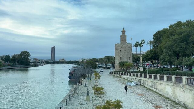 Panoramic view of the Torre del Oro in Seville next to the Guadalquivir River on a cloudy day