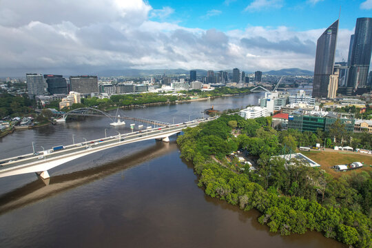 Aerial view of cityscape featuring Brisbane River, Captain Cook Bridge, Goodwill Bridge, and modern skyscrapers, Brisbane City, Australia.