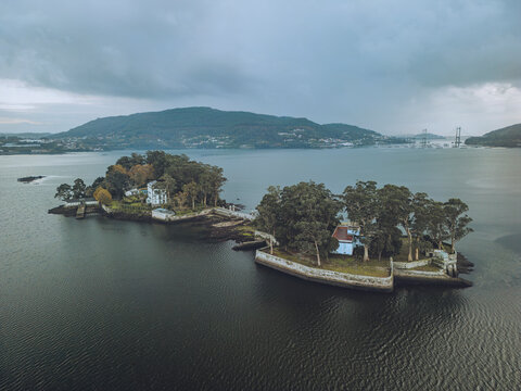 Aerial view of san simon island surrounded by tranquil water and picturesque shoreline, redondela, spain.