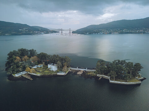 Aerial view of San Simon Island surrounded by tranquil water and scenic landscape, Redondela, Spain.