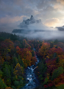 Aerial view of majestic Corne du Chamois surrounded by vibrant autumn forest and a winding river, Sixt-Fer-a-Cheval, France.