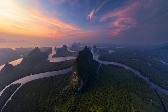 Aerial view of majestic Khao Ma Chu with lush mountains and a tranquil river at sunset, Mueang Phang Nga, Thailand.