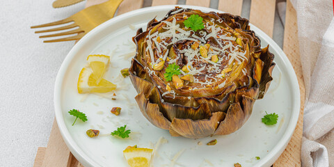 Delicious baked artichoke with parmesan cheese and pistachio. Olive oil, garlic, parsley and lemon