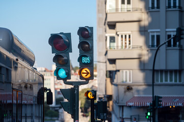 Traffic lights show red and green signals, indicating movement for vehicles and buses.