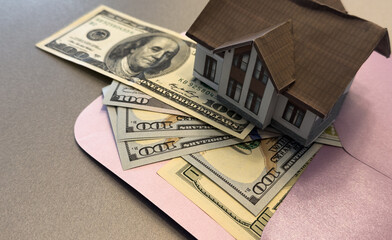 property, real estate, financial, loan, wealth, investment, construction, estate, insurance, residential. A car is on a table next to a house. The car is a toy and the house is a model.