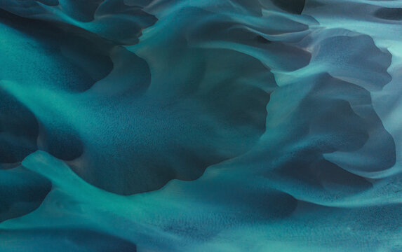 Aerial view of beautiful turquoise water with abstract patterns and smooth waves, Selfoss, Iceland.