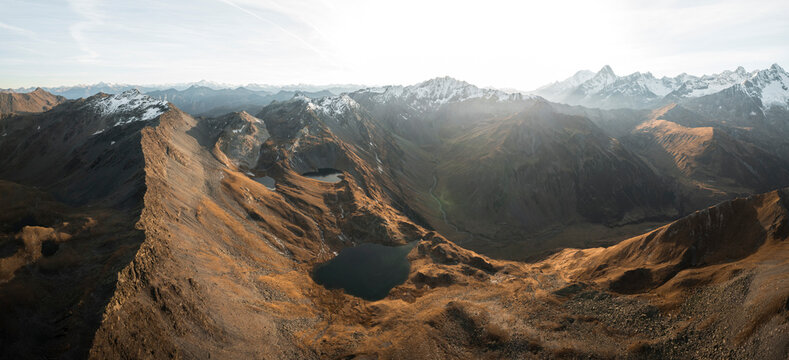 Aerial view of lacs de fenetre surrounded by majestic mountains and a tranquil valley at sunset, La Fouly, Switzerland.