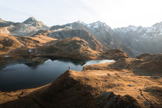 Aerial view of serene Lacs de Fenetre surrounded by majestic mountains at sunset, La Fouly, Switzerland.