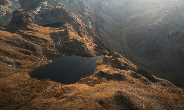 Aerial view of Lacs de Fenetre at sunset surrounded by majestic mountains and a tranquil valley, La Fouly, Switzerland.