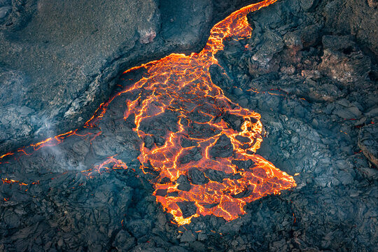 Aerial view of flowing lava from a volcanic eruption amidst a majestic landscape, Sundhnukur, Grindavik, Iceland.