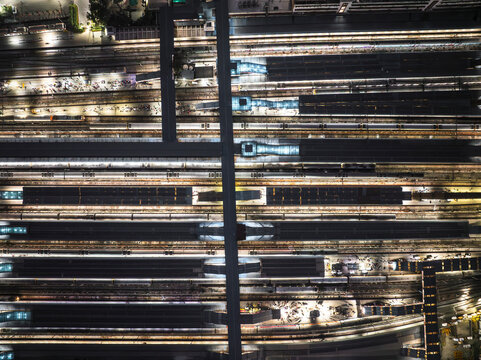 Aerial view of bustling Ajmeri Gate train station with vibrant lights and busy urban activity, New Delhi, India.