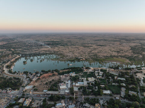 Aerial view of tranquil Amar Sagar Pol with beautiful lake and historic buildings in desert landscape, Jaisalmer, Rajasthan, India.