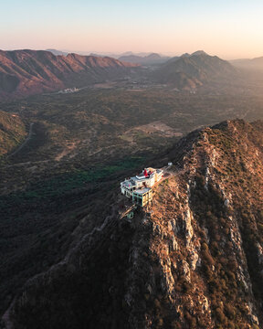 Aerial view of serene and majestic Shree Savitri Mata Temple on a hilltop with picturesque rocky terrain, Pushkar, Rajasthan, India.