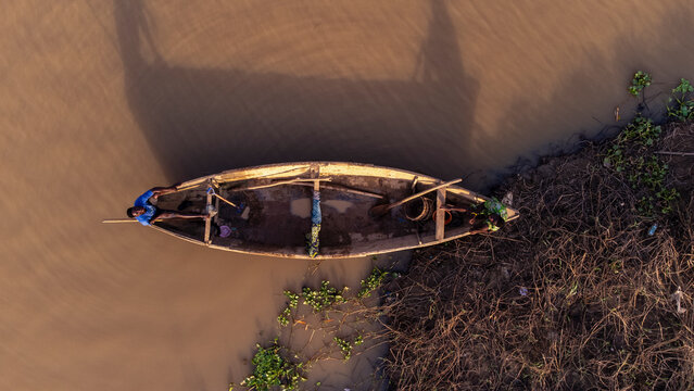 Aerial view of serene Ogun River with traditional wooden boats and lush vegetation, Ifo, Nigeria.
