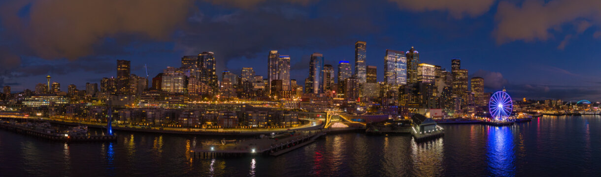 Aerial view of illuminated skyline and waterfront with Seattle Big Wheel at twilight, Elliot Bay, United States.