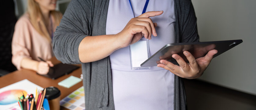 Graphic designer presenting ideas on a tablet in a collaborative workspace. - Powered by Adobe