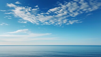 Peaceful ocean view under a clear blue sky with soft clouds