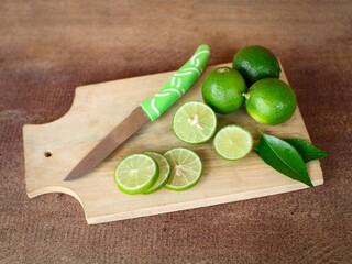 Close-up, thinly sliced ​​fresh lime laid on a wooden cutting board