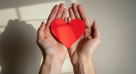 Fototapeta premium Hands holding red heart symbol expressing love and care