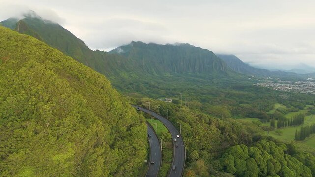 Aerial view of lush pali highway winding through serene koolau mountain range and verdant forest, Kailua, United States.