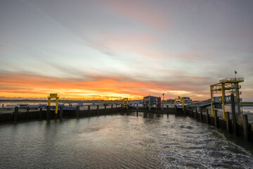 Fototapeta premium Landscape near Dagebüll harbor. Nature with sunrise on the North Sea coast. Rising sun on the sea. 