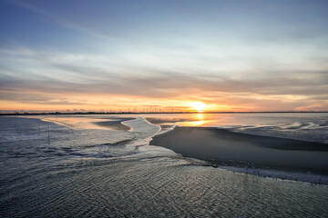 Fototapeta premium Landscape near Dagebüll. Nature with sunrise on the North Sea coast. Rising sun on the sea. 