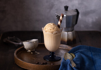 Homemade coffee ice cream in a glass on a rustic wooden table.