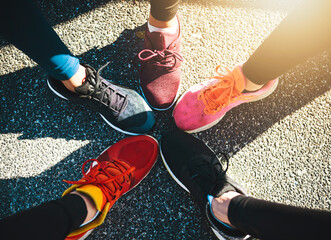 People, shoes and feet with asphalt for fitness, sports fashion or training on road or street together above. Top view, sneakers or runners with circle in unity for huddle, team motivation or running