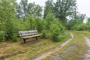 Gees, The Netherlands - June, 21, 2024: Wooden bench with Dutch text Drenthepad along the long...