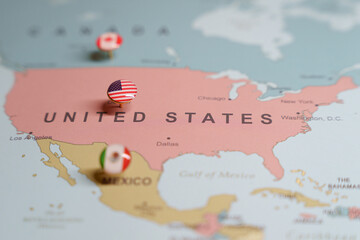  US flag push pin marking the United States on a map, with Mexico and Canada location pins visible