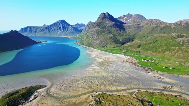 Aerial view of Morpheus Beach at low tide surrounded by a scenic mountain landscape and tranquil fjord, Flakstad, Norway.