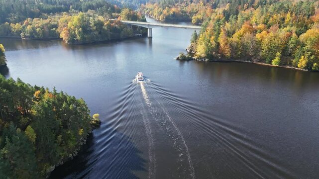 Aerial view of serene Stausee Ottenstein with vibrant autumn foliage and a tranquil boat cruise, Zwettl, Austria.