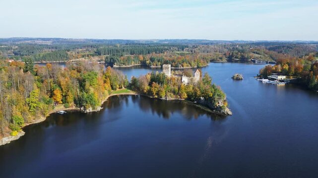 Aerial view of serene Stausee Ottenstein with a picturesque castle ruin on a tranquil peninsula surrounded by autumnal forest, Zwettl, Austria.