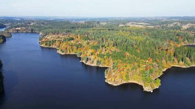 Aerial view of serene Stausee Ottenstein with autumn foliage and a scenic castle ruin, Zwettl, Austria.