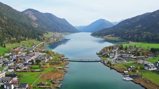 Aerial view of idyllic landscape with a serene lake, picturesque village, and tranquil mountains, Weissensee, Austria.