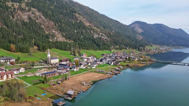 Aerial view of idyllic landscape with a serene lake and picturesque village surrounded by mountains, Weissensee, Austria.