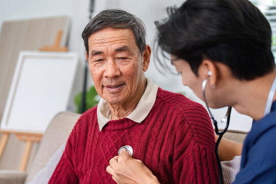 Nurse using stethoscope to check elderly man's heart during a home health check-up