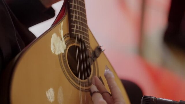 Close up of musician playing Portuguese guitar during fado performance