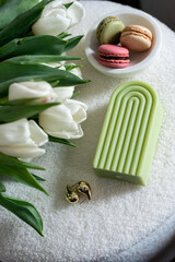 Cup with cappuccino and macarons, spring flowers tulips, morning concept, soy candle, woman's day, bedroom design