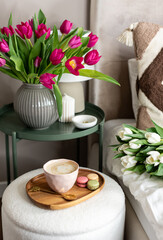 Cup with cappuccino and macarons, spring flowers tulips, morning concept, soy candle, woman's day, bedroom design
