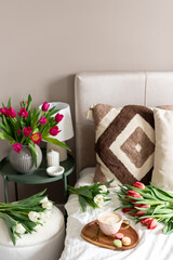 Cup with cappuccino and macarons, spring flowers tulips, morning concept, soy candle, woman's day, bedroom design