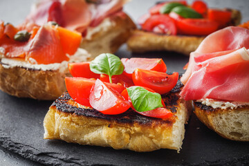 delicious Italian bruschetta with tomatoes salmon and prosciutto